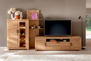 Helles Holz-Highboard mit Glastür und Regalen, dekoriert mit Vasen und Blumen, in einem modernen Wohnzimmer. Perspektive von vorne.