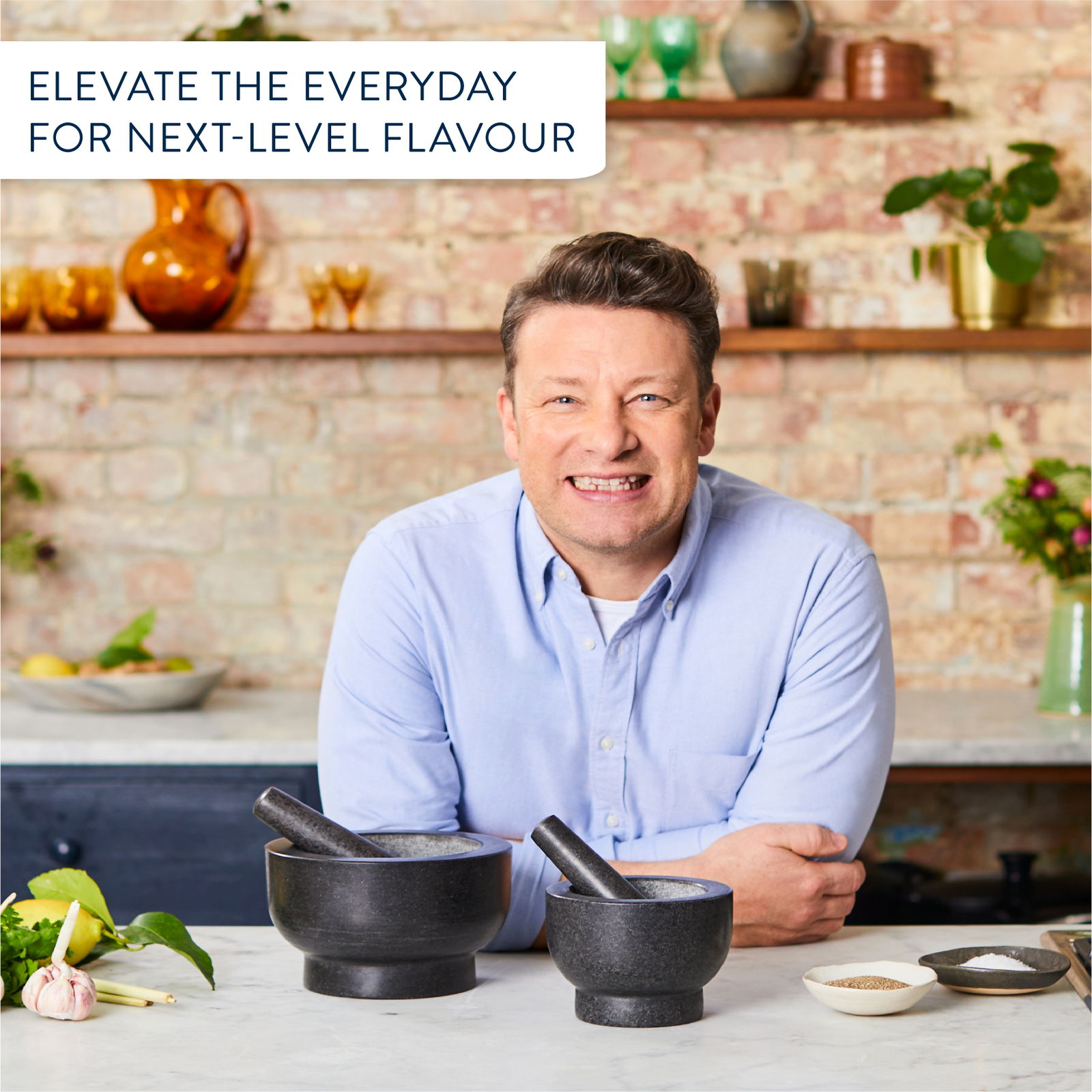 Zwei schwarze Mörser und Stößel auf einer Küchenarbeitsplatte, frontal fotografiert, mit einem Mann im Hintergrund.