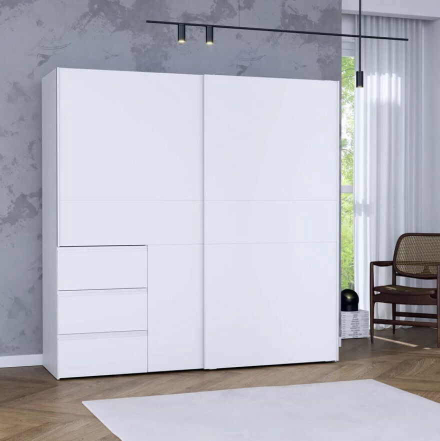 Moderner weißer Schwebetürenschrank mit drei Schubladen, frontal fotografiert in einem stilvoll eingerichteten Raum.