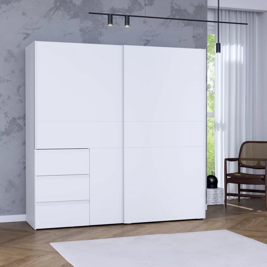Moderner weißer Schwebetürenschrank mit drei Schubladen, frontal fotografiert in einem stilvoll eingerichteten Raum.