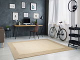 Moderner heller Wollteppich in einem stilvollen Arbeitszimmer mit Schreibtisch, Fahrrad und Wanddekorationen, aus der Vogelperspektive betrachtet.