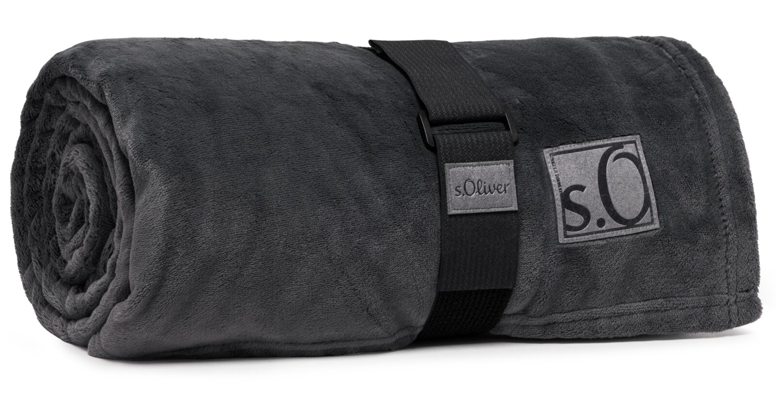 Graue, zusammengerollte Kuscheldecke von s.Oliver mit schwarzem Tragegurt, seitliche Perspektive