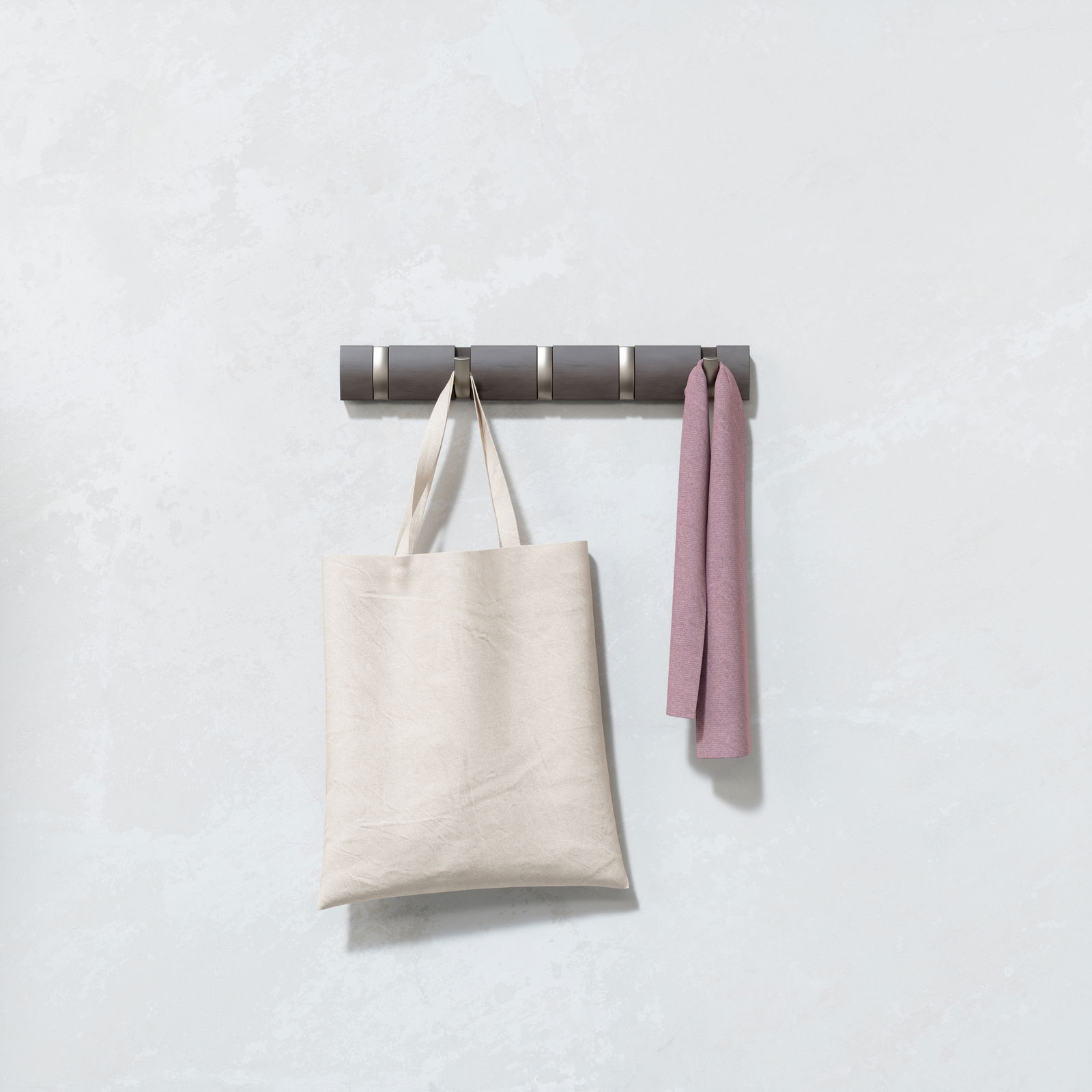 Wandgarderobe mit mehreren Haken, an denen eine beige Tasche und ein rosa Tuch hängen, seitliche Perspektive