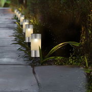 Solarbetriebene Stabbeleuchtung aus Edelstahl entlang eines Gartenwegs, seitliche Perspektive