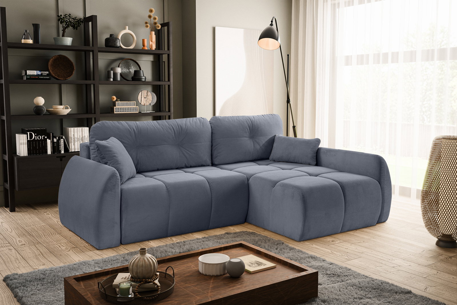 Eckschlafsofa in Blau, rechts ausgerichtet, in einem modernen Wohnzimmer mit Bücherregal und Stehlampe, seitliche Perspektive