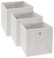 Drei weiße Stoffboxen in verschiedenen Größen, frontal und leicht seitlich angeordnet, mit Metallösen an der Vorderseite.