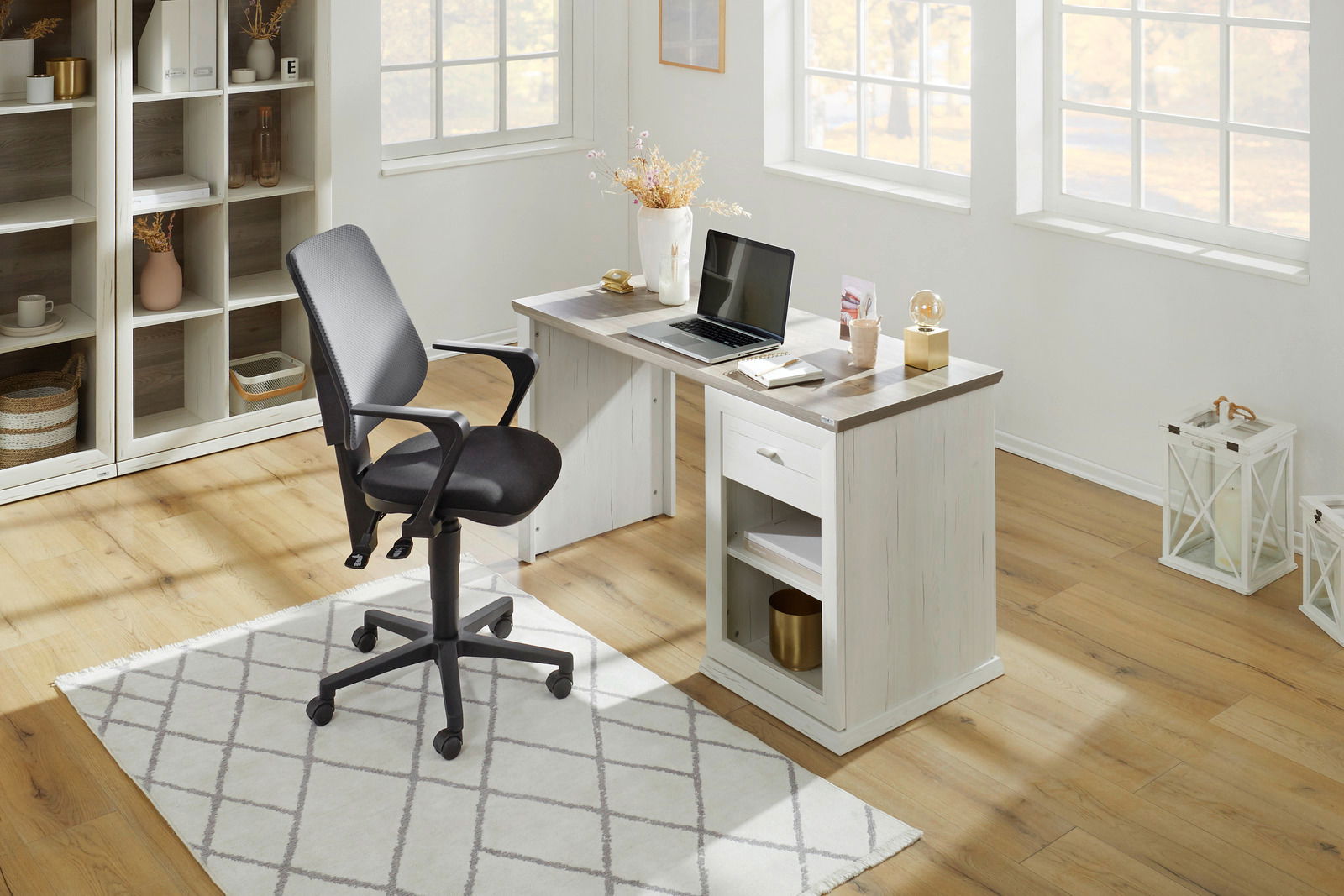 Moderner Schreibtisch in heller Holzoptik mit Laptop und Dekoration, seitliche Perspektive