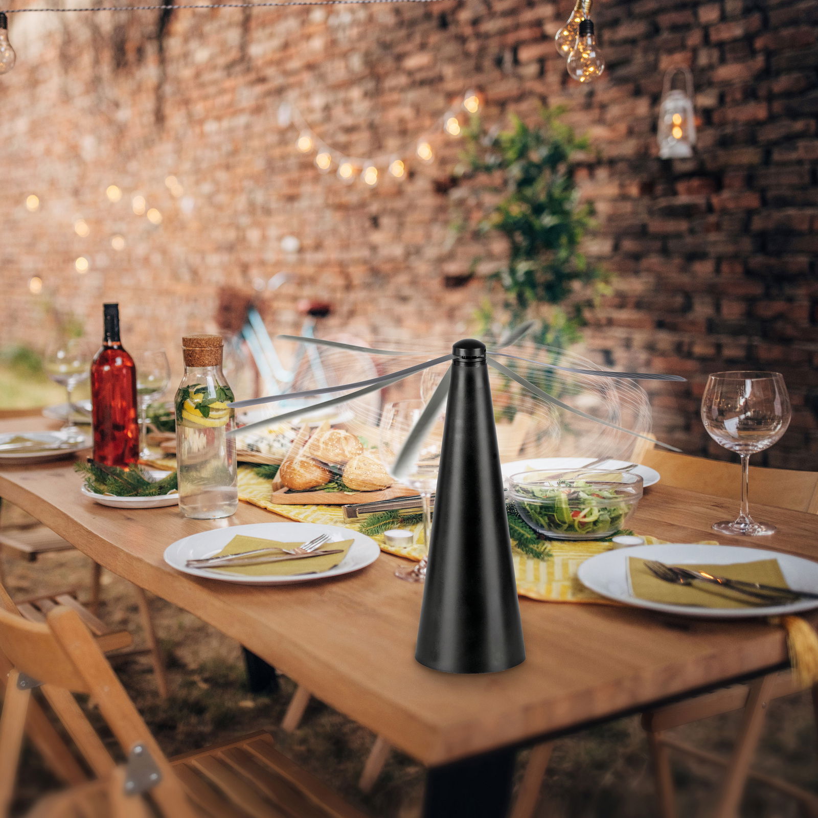 Fliegenwedler auf einem gedeckten Tisch im Freien, mit Tellern, Gläsern und einer gemütlichen Atmosphäre im Hintergrund.