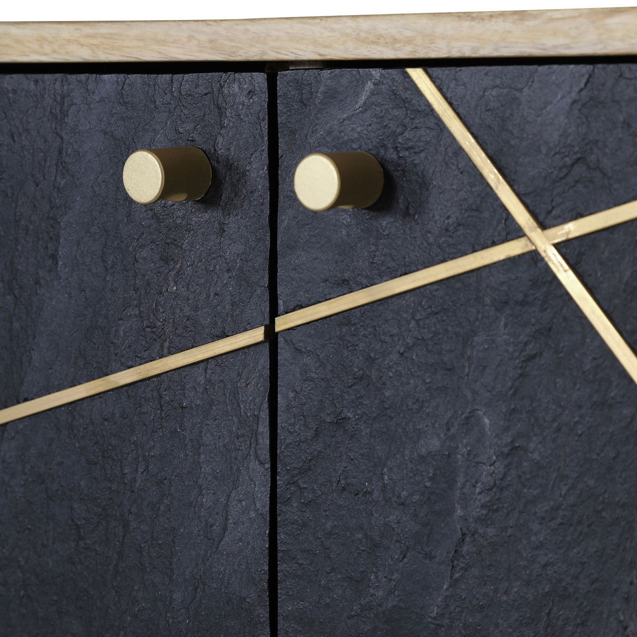 Nahaufnahme einer Kommode mit dunkler, strukturierter Oberfläche und goldenen Griffen sowie diagonalen Zierleisten, von vorne betrachtet.