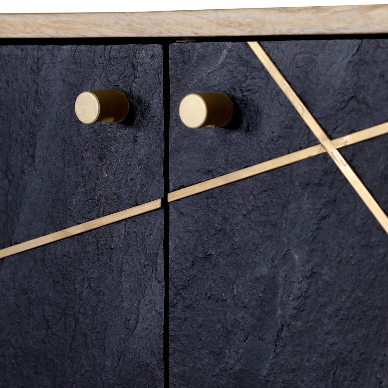 Nahaufnahme einer Kommode mit dunkler, strukturierter Oberfläche und goldenen Griffen sowie diagonalen Zierleisten, von vorne betrachtet.