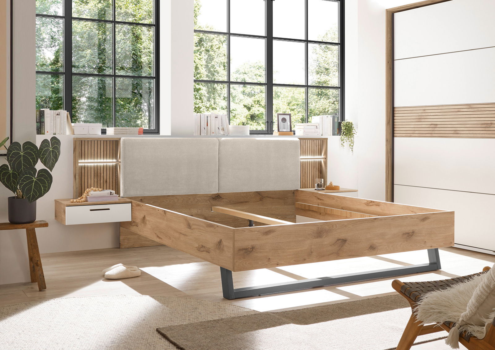 Moderne Bettanlage aus Holz mit gepolstertem Kopfteil, seitlichen Schubladen und stilvoller Beleuchtung, seitliche Perspektive