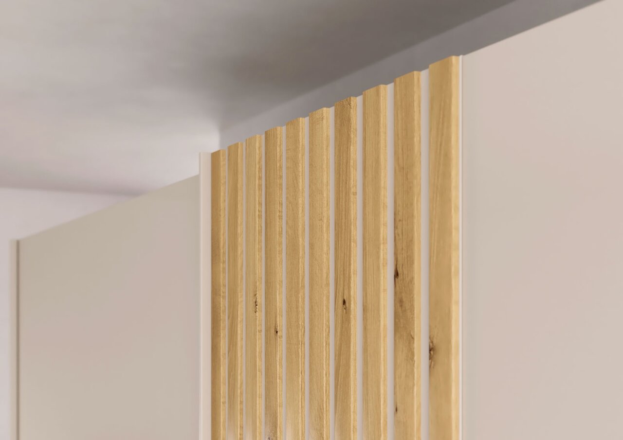 Close-up van een zweefdeurkast met twee deuren, met verticale houten latten op een crèmekleurig oppervlak, gezien vanuit een bovenaanzicht.