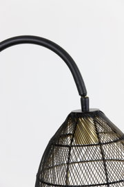 Detailopname in zijaanzicht van een zwarte metalen lamp met gebogen arm, open draadkap en goudkleurig accent