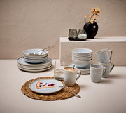 Kombiservice 20-tlg. in eleganter Tischdekoration, bestehend aus Tellern, Schalen und Tassen in sanften Blautönen, seitliche Perspektive.