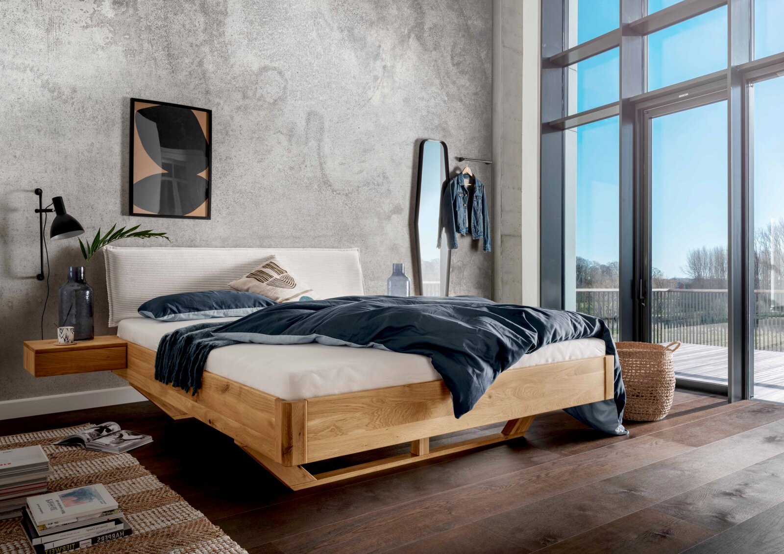 Massivholzbettgestell in einem modernen Schlafzimmer mit großen Fenstern, seitliche Perspektive.