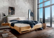 Massivholzbettgestell in einem modernen Schlafzimmer mit großen Fenstern, seitliche Perspektive.