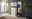 Hom´in Schuhschrank CAMRON Heller Flur mit einem weißen Schuhschrank und Garderobenpaneel, dekoriert mit Pflanzen und Accessoires, seitliche Perspektive.