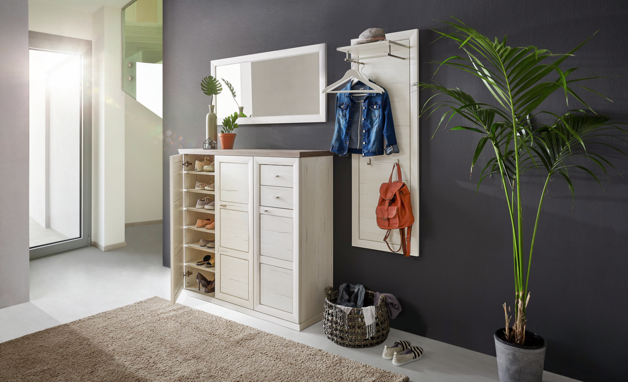 Hom´in Spiegel CAMRON Heller Flur mit einem weißen Schuhschrank und Garderobenpaneel, dekoriert mit Pflanzen und Accessoires, seitliche Perspektive.