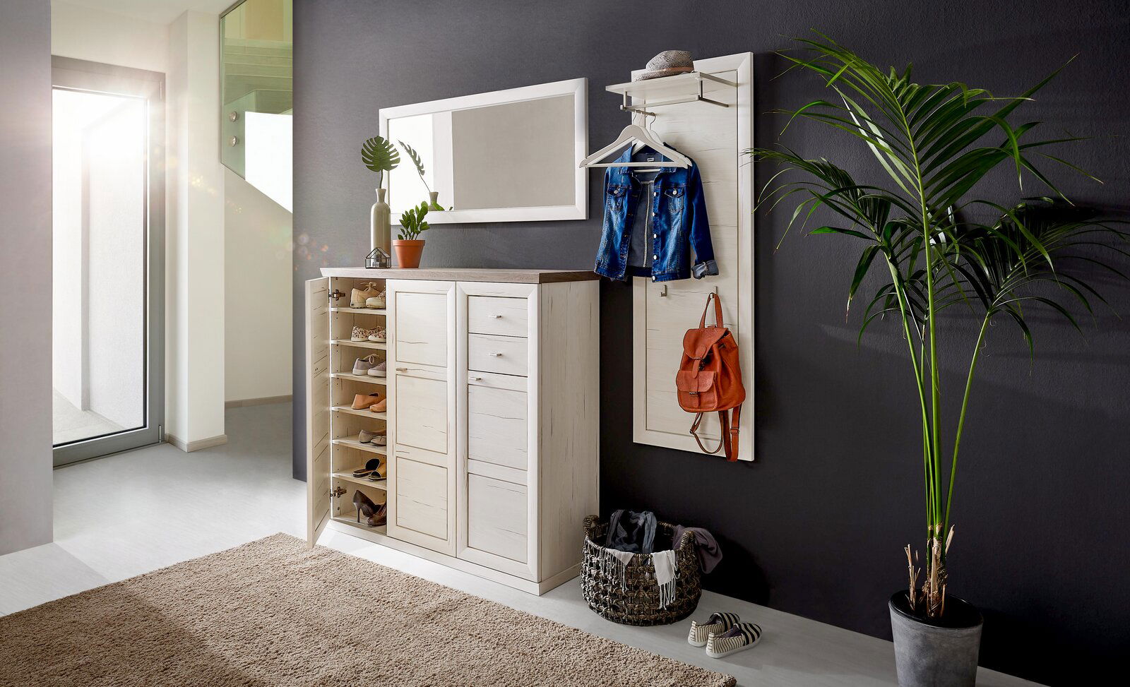 Hom´in Spiegel CAMRON Heller Flur mit einem weißen Schuhschrank und Garderobenpaneel, dekoriert mit Pflanzen und Accessoires, seitliche Perspektive.