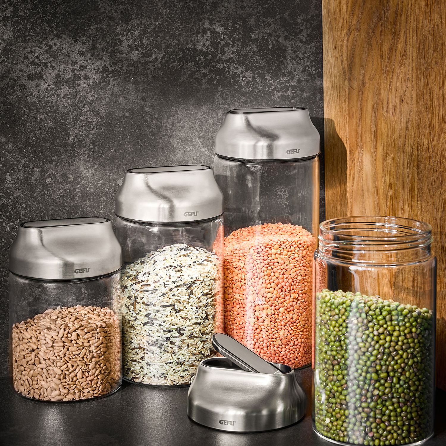 GEFU Vorratsdosen 700 ml, 2er-Set KIPPO Vorratsdosen aus Glas mit Edelstahl-Deckeln, gefüllt mit verschiedenen Lebensmitteln, aus seitlicher Perspektive fotografiert.