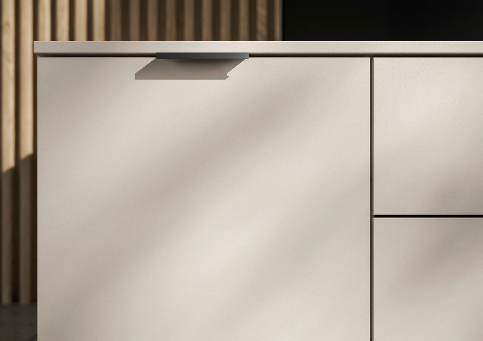 Nahaufnahme eines modernen XL-Sideboards in hellem Beige mit minimalistischen Griffen, seitliche Perspektive
