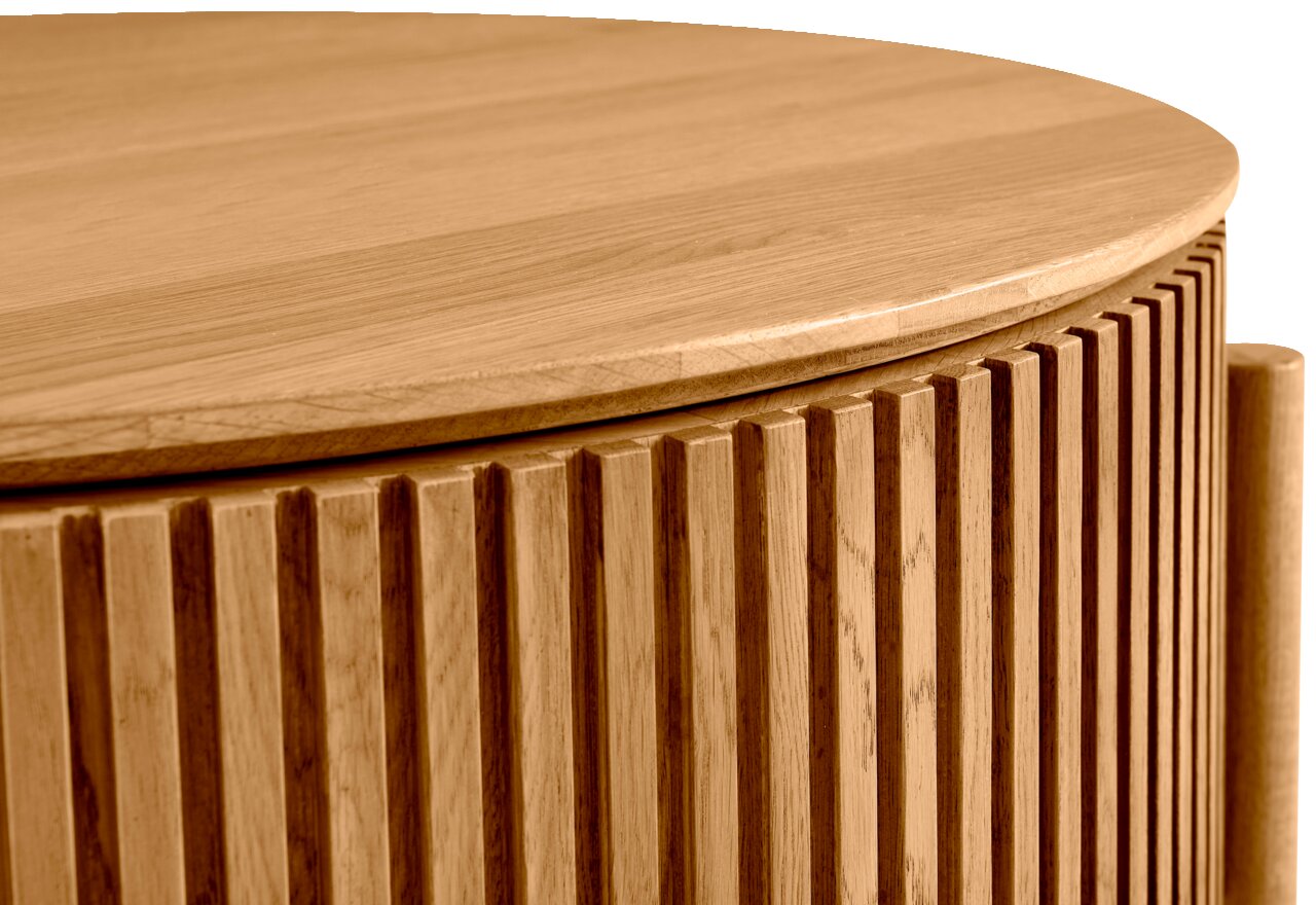 Nahaufnahme eines runden Couchtisches aus Holz mit geriffelter Oberfläche, seitliche Perspektive
