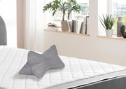 Grauer Leseknochen auf einem weißen Bett, seitliche Perspektive