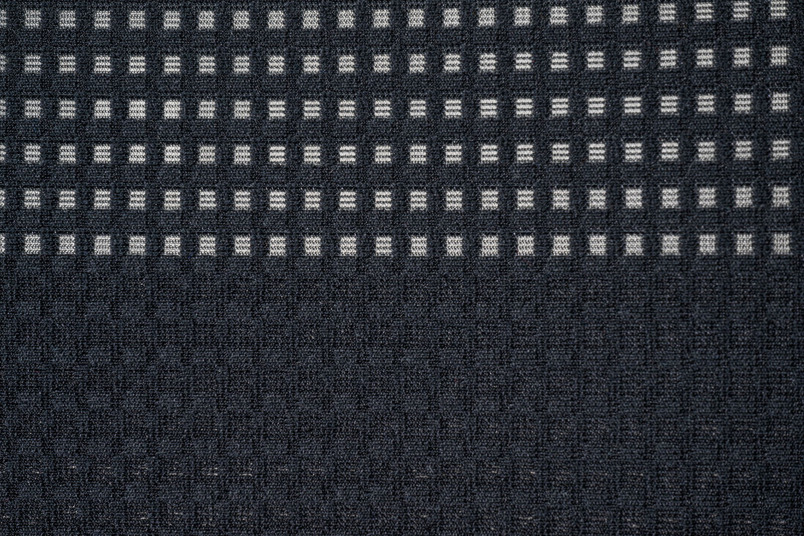 Nahaufnahme eines Bürostuhlbezugs mit grauem Karomuster