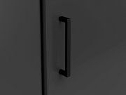 Nahaufnahme eines schwarzen Griffs an einer dunklen Eckkommode, seitliche Perspektive