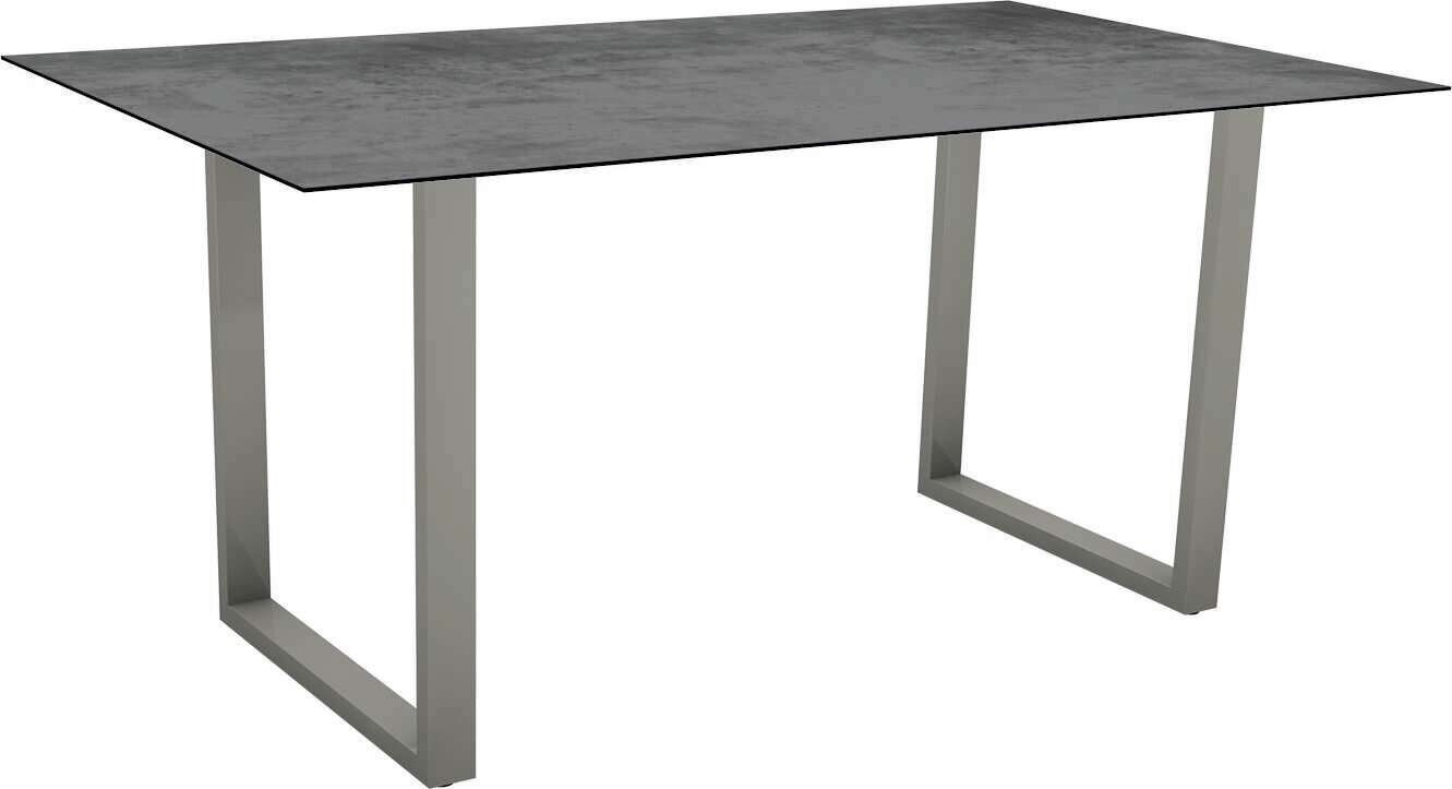 Moderner Gartentisch mit rechteckiger, dunkler Tischplatte und stabilen, grauen Metallbeinen, seitliche Perspektive.