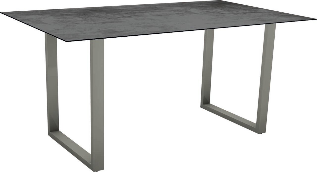 Moderner Gartentisch mit rechteckiger, dunkler Tischplatte und stabilen, grauen Metallbeinen, seitliche Perspektive.