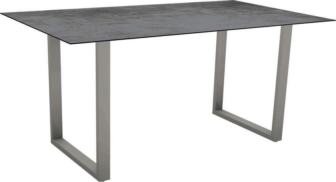 Moderner Gartentisch mit rechteckiger, dunkler Tischplatte und stabilen, grauen Metallbeinen, seitliche Perspektive.