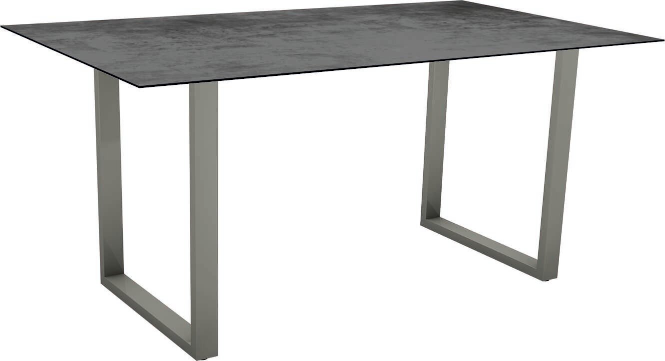 Moderner Gartentisch mit rechteckiger, dunkler Tischplatte und stabilen, grauen Metallbeinen, seitliche Perspektive.