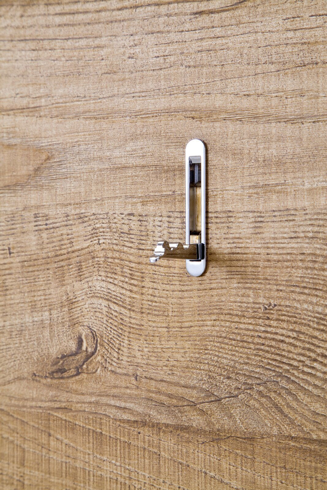 Nahaufnahme eines Garderobenhakens auf einer Holzoberfläche, seitliche Perspektive