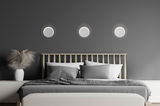 Moderne LED-Wandleuchten über einem Bett in einem stilvollen Schlafzimmer, frontal betrachtet.