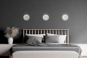 Moderne led-wandlampen boven een bed in een stijlvolle slaapkamer, gezien van voren.