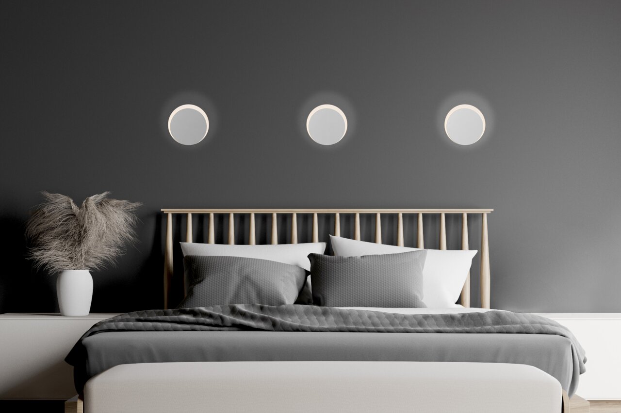 Moderne led-wandlampen boven een bed in een stijlvolle slaapkamer, gezien van voren.