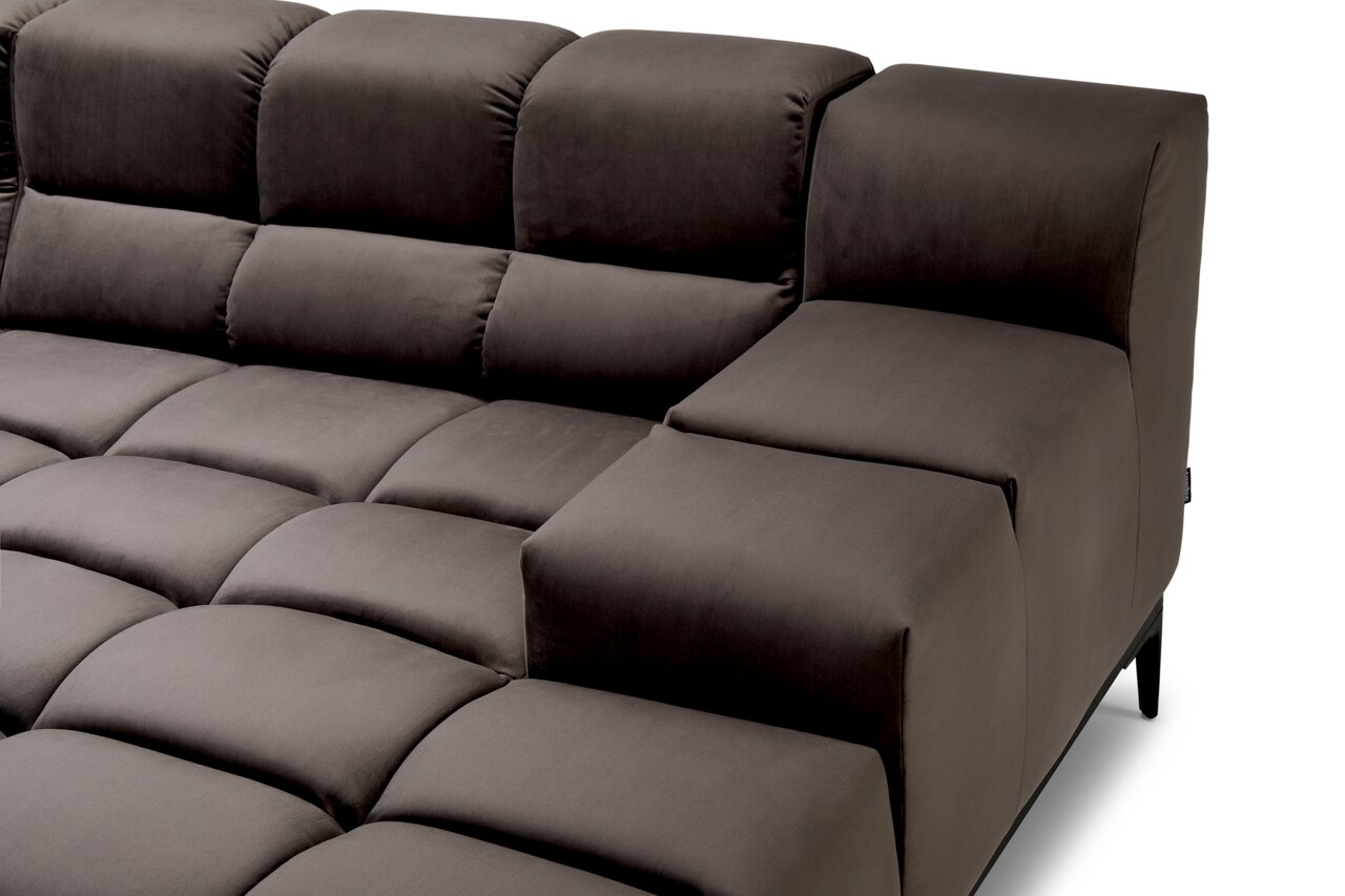 Close-up van een moderne, donkergrijze longchair-set met gestoffeerde zit- en rugkussens, gezien vanaf de zijkant.