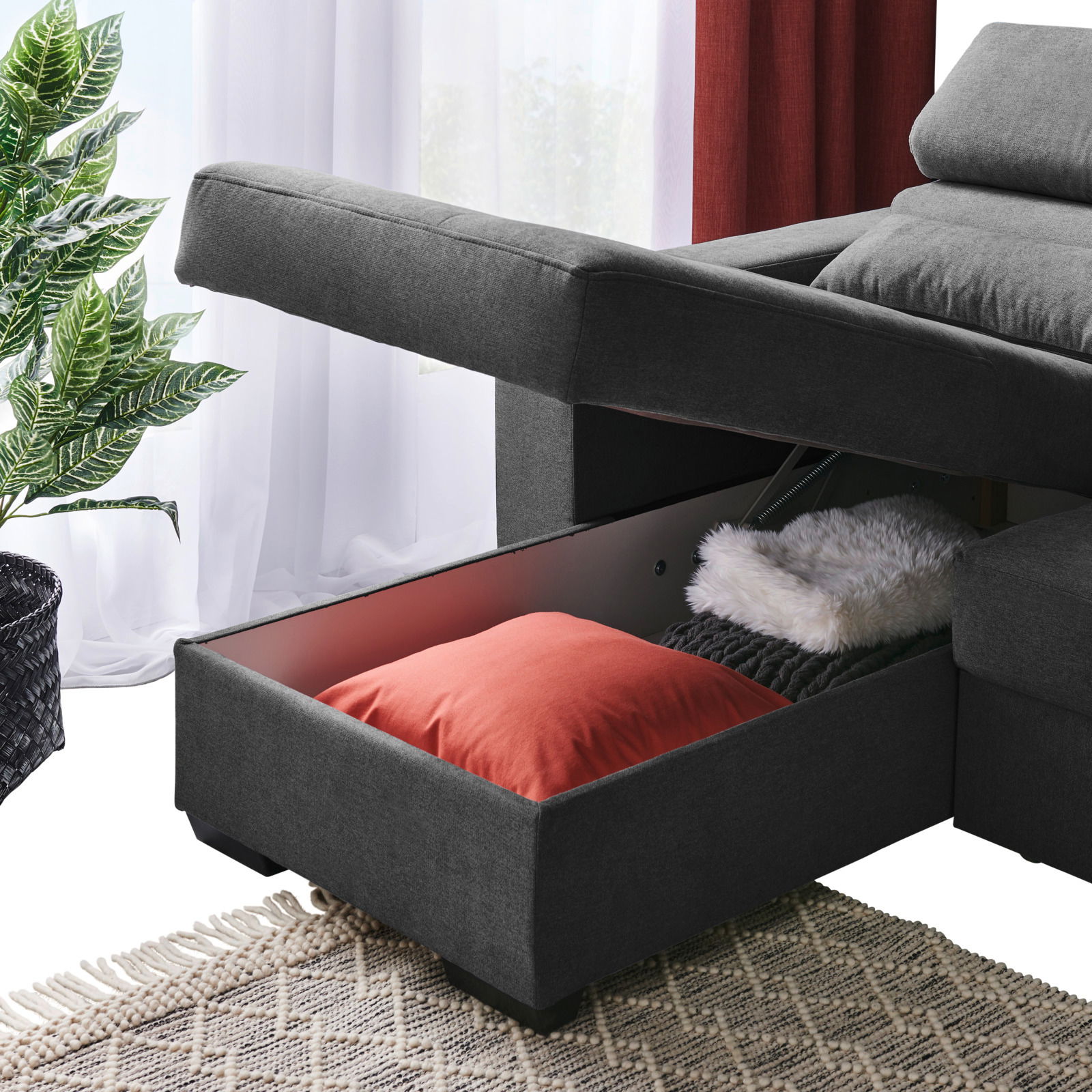 Graue Rundecke mit Stauraum, geöffnet, mit Kissen und Decke, seitliche Perspektive