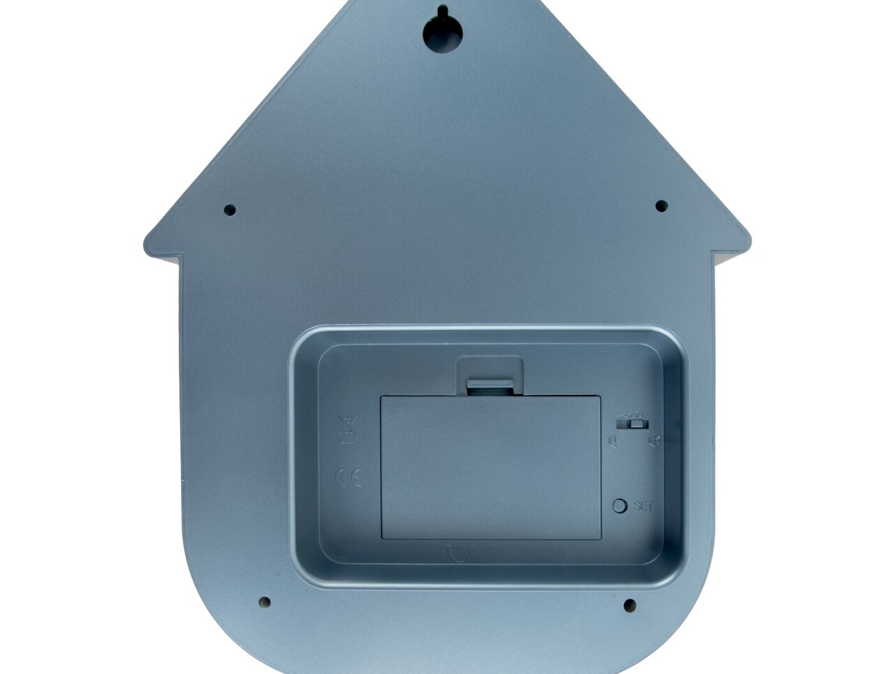 Achterkant van een wandklok in de vorm van een huisje, met batterijvak en ophangbeugel.
