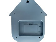 Achterkant van een wandklok in de vorm van een huisje, met batterijvak en ophangbeugel.