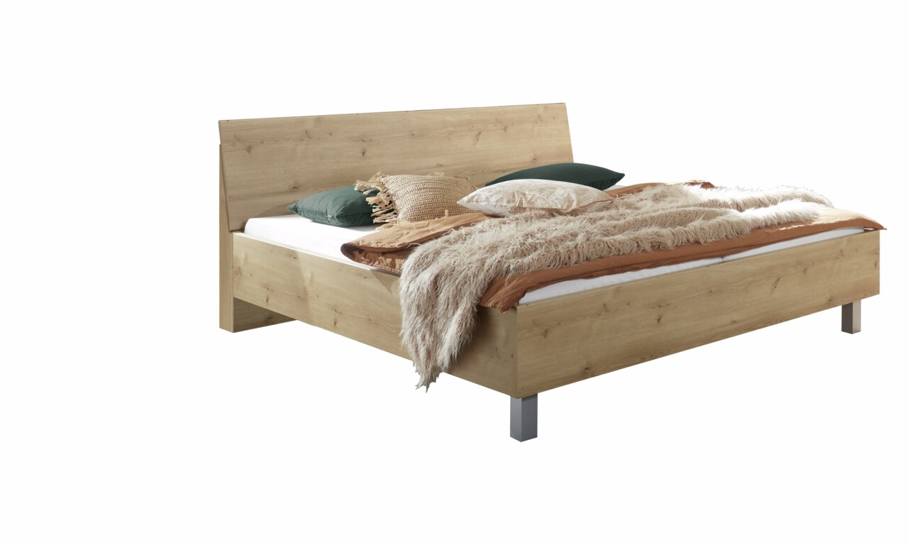 Houten futonbed in zijaanzicht, versierd met kussens en dekens