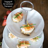 Dreistufige weiße Etagere mit Lachs-Canapés, von oben fotografiert, mit praktischem Tragegriff für sicheren Transport.
