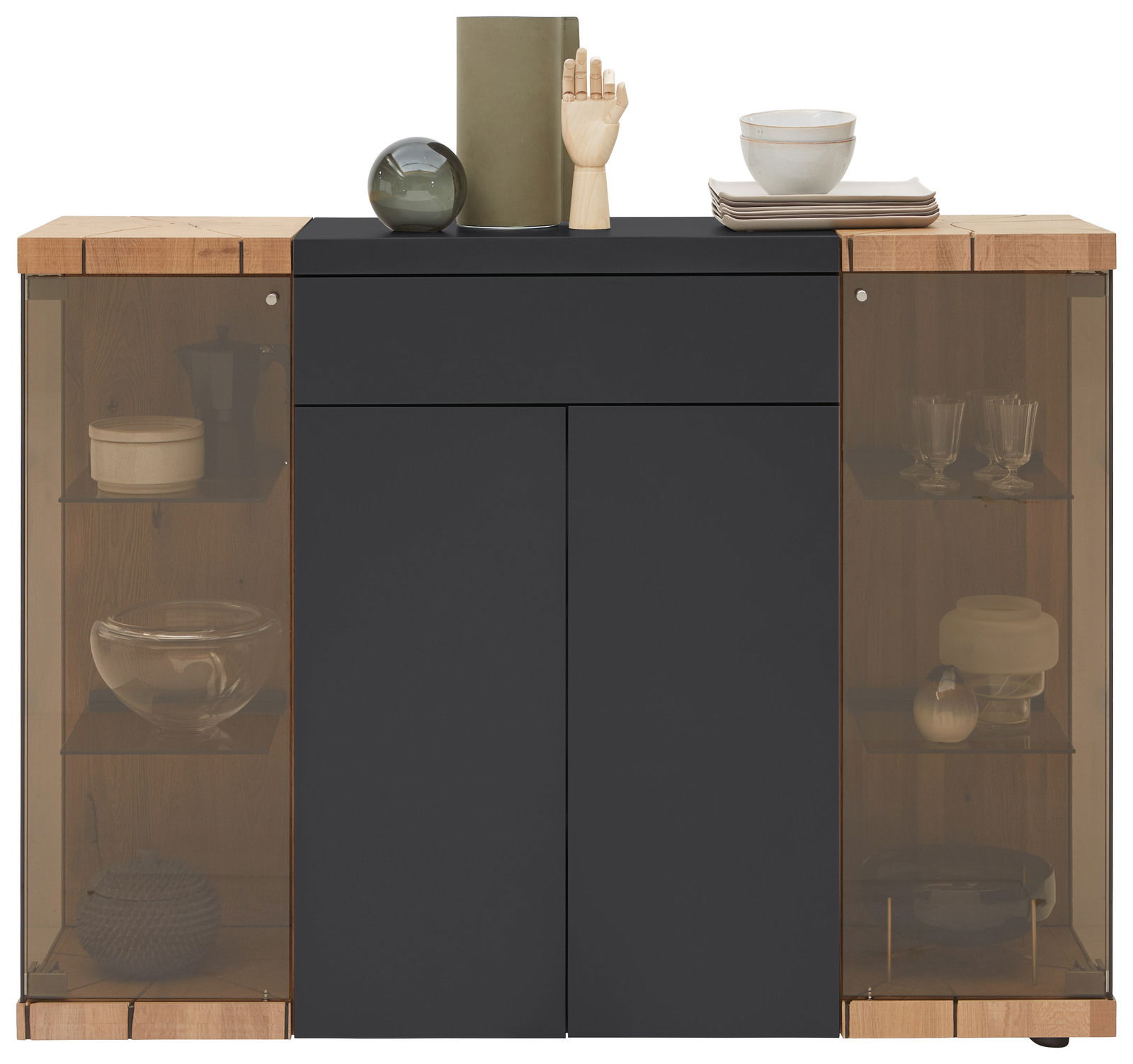 Frontale Ansicht eines modernen Highboards mit dunkler Oberfläche und Holzelementen, ausgestattet mit Glastüren und dekorativen Objekten auf der Oberseite.