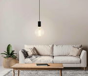 Moderne Pendelleuchte POZUETA mit großer Glühbirne, hängend über einem gemütlichen Wohnzimmer mit Sofa und Holztisch, aus frontaler Perspektive.