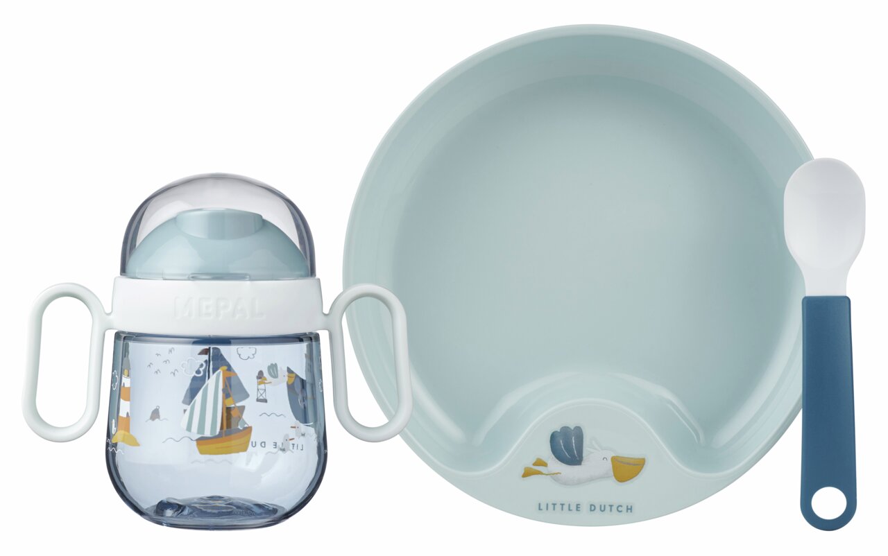 Set babybestek bestaande uit een blauw bord, een beker met handvatten en een lepel, met maritieme motieven, gezien vanuit vogelperspectief.
