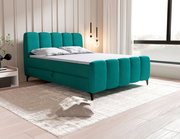 Modernes Boxbett in Türkis mit gepolstertem Kopf- und Fußteil, seitliche Perspektive im stilvollen Schlafzimmer.