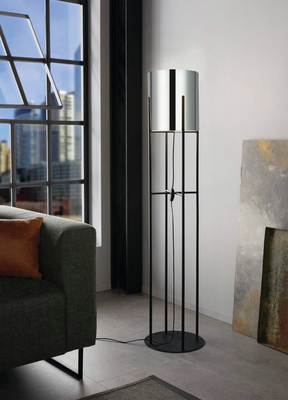 Moderne Stehleuchte GLASTONBURY in einem Wohnzimmer, seitliche Perspektive, mit schwarzem Metallgestell und zylindrischem Lampenschirm.