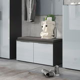 Moderne Garderobenbank mit grauem Sitzpolster, zwei Türen und glänzender Oberfläche, seitliche Perspektive.