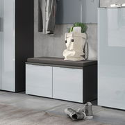 Moderne Garderobenbank mit grauem Sitzpolster, zwei Türen und glänzender Oberfläche, seitliche Perspektive.